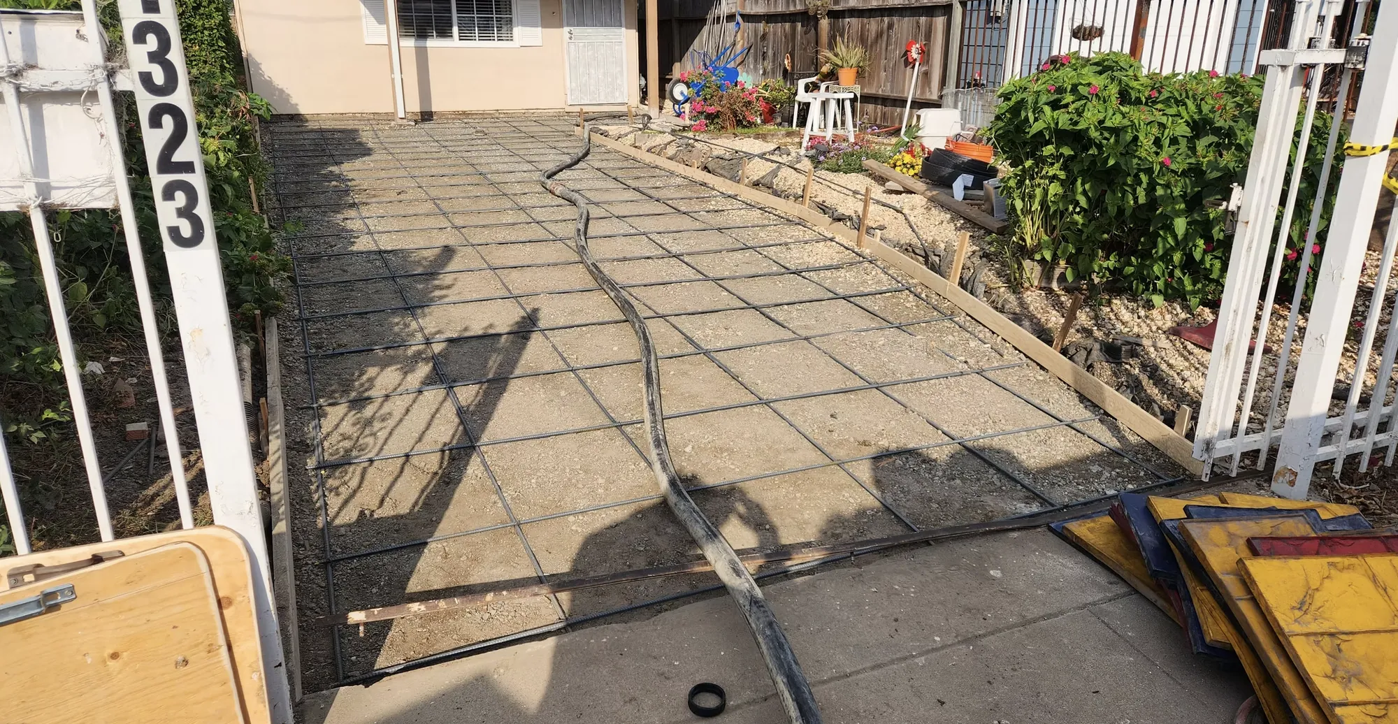 Concrete walkway with a scored square pattern leading to a house entry
